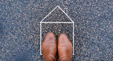 Drawing of a house on the road, feet standing inside, planning to buy or rent a new home, real estate concept, owning property