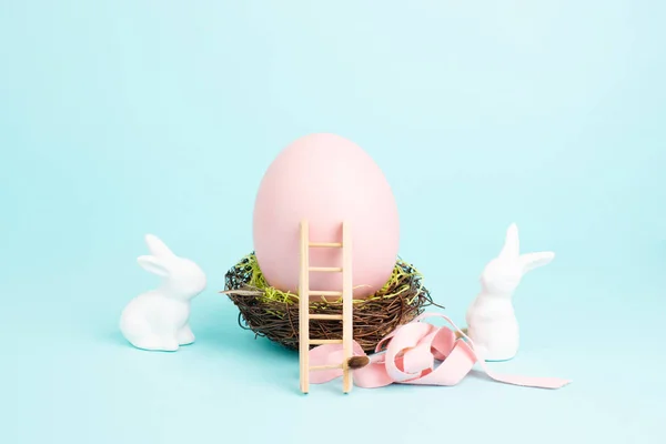 Osterhase Oder Hase Sitzt Neben Einem Riesigen Rosafarbenen Vogelnest Geschenkband — Stockfoto