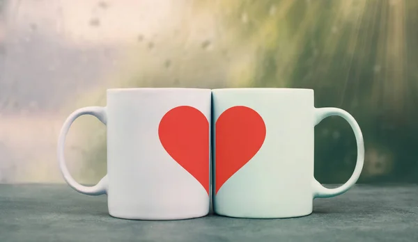Mug couple with a huge heart on a window sill cuddle, cup of coffee, relationship and friendship concept, love