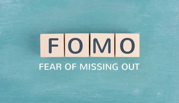 stock image FOMO acronym for fear of missing out, social media and lifestyle concept, regret and depression, state of mind