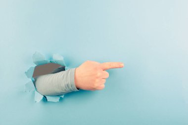 Parmaklar doğru yönü gösterir, reklam ve pazarlama için kopyalama alanı, dikkat hareketi, mavi yırtık kağıt deliği