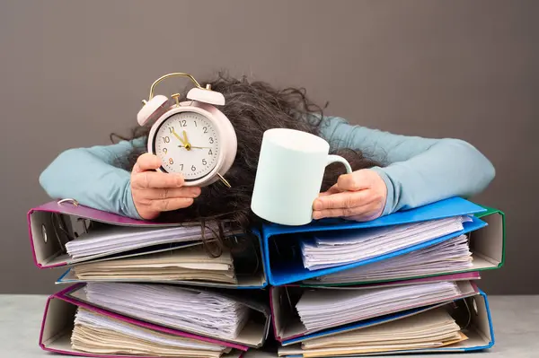 Kahveli ve alarmlı yorgun bir kadın, dosya klasörleri, patinaj, stres ve aşırı çalışma, işte baskı. 