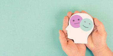 Üzgün ve mutlu bir yüze, ruh sağlığı konseptine, olumlu ve olumsuz zihne, depresyona, desteğe ve duyguya sahip bir kafa tutmak, bölünmüş kişilik.