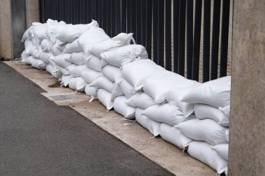 Sandbags for flood defense, river Moselle Trier in Rhineland Palatinate, flooded trees and paths, high water level, climate change  clipart