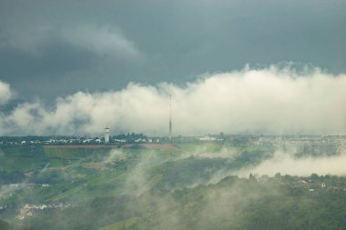 Almanya 'nın Trier şehrinde kara fırtına bulutları, üzüm bağları, tarım arazisi ve ormanlık arazi, yazın yağışlı hava