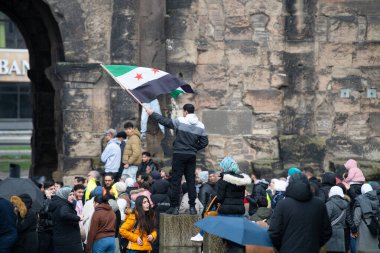 Suriyeliler, Esad rejiminin devrilmesi, Orta Doğu 'daki savaş, isyancılar ve İslamcılar, Almanya' nın Trier kentindeki Porta Nigra, 08.12.2024 'te kutluyorlar.