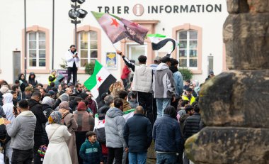 Suriyeliler, Esad rejiminin devrilmesi, Orta Doğu 'daki savaş, isyancılar ve İslamcılar, Almanya' nın Trier kentindeki Porta Nigra, 08.12.2024 'te kutluyorlar.