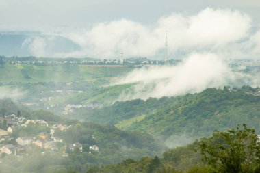Almanya 'nın Trier şehrinde kara fırtına bulutları, üzüm bağları, tarım arazisi ve ormanlık arazi, yazın yağışlı hava