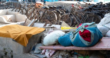 Dhobi Ghat, Mumbai, Hindistan 'da açık hava çamaşırları, çuvalda temiz giysiler, çarşaf ve çarşaf yıkama, bisiklet gibi işçiler.