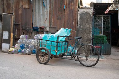 Boş içme suyu şişeleriyle dolu eski bisiklet, plastik kutu yeniden kullanım, triportör taşıma, geri dönüşüm, çevre sorunu, Mubai, Hindistan, 06.03.2025