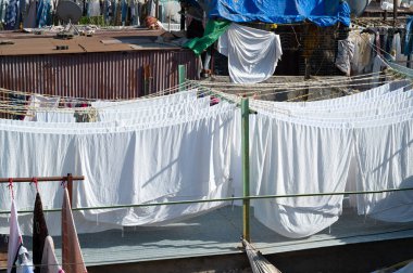 Dhobi Ghat, Mumbai, Hindistan 'da açık hava çamaşırları, çamaşır ipine asılı temiz giysiler, çarşaf ve çarşaf yıkamak.