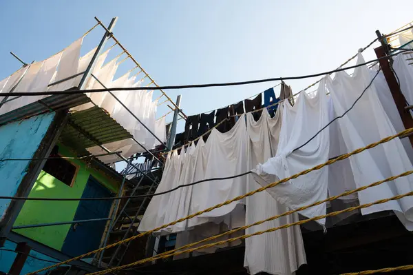 Dhobi Ghat, Mumbai, Hindistan 'da açık hava çamaşırları, çamaşır ipine asılı temiz giysiler, çarşaf ve çarşaf yıkamak.