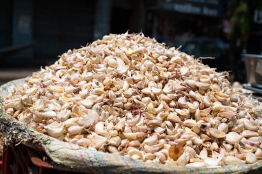 Sarımsak soğanları yığını, Hindistan 'da baharat pazarı tezgahı, satılık baharatlı gıda malzemeleri.