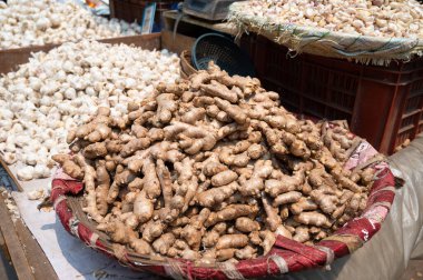 Zencefil kökü ve sarımsak yığını, Hindistan 'da baharat pazarı tezgahı, satılık baharatlı gıda malzemeleri.