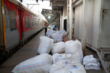 Mumbai, Hindistan tren istasyonu, yatak çarşaflı çantalar, yataklı tren platformu, toplu taşıma ve teslimat, 05.03.2025