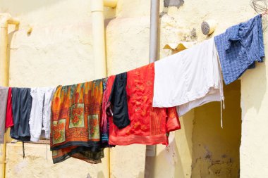 Çamaşır ipinde kuruması için giysiler, Hindistan 'da eski ev cephesi, yaşam tarzı ve kültür, çürüyen duvar.