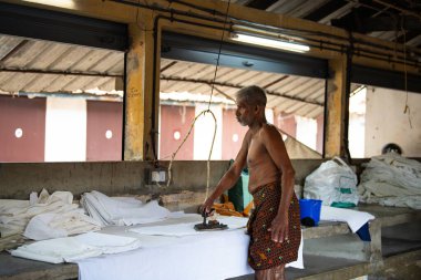 Eski elektrikli ütüyle ütü, Dhobi Ghat, Kochi, Hindistan 'da hava çamaşırları, 29.03.2025