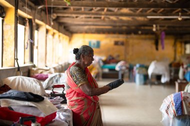 Geleneksel elbiseli kadın Dhobi Ghat 'ta çalışıyor, Kochi, Hindistan' da açık hava çamaşırhanesi, 29.03.2025