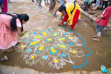 Kolam, Holi festivali akşamında kadınlar ve kızlar tarafından çizilmiş renkli kum boyası, Holika Dahan ateşi, Hindistan, Hint dini kültürü, hinduizm kutlaması, Hampi 14.03.2025