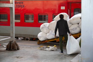 Mumbai, Hindistan tren istasyonu, yatak çarşaflı çantalar, yataklı tren platformu, toplu taşıma ve teslimat, 06.03.2025