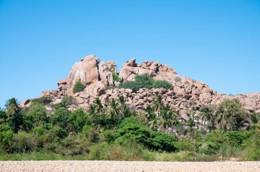 Tungabhadra nehrinde çalıları ve ağaçları olan Hampi kayaları, kayalık arazi, Güney Hindistan, Karnataka
