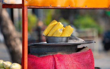 Bir kasede taze mısır koçanı, Hindistan 'da sokak yemeği, market tezgahı, sağlıklı beslenme, buğulanmış ve ızgara sebze satışı.