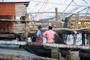 Kochi, Kerala, Cheena vala ya da Tangkul kıyılarındaki Çin balıkçı ağlarının yanındaki balıkçılar, geleneksel sabit asansör ağı, 20 Mart 2025