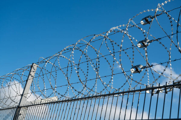 Barbed wire, border control, illegal immegration and migration, refugee camp, prison fence, coils of razor wires, protection and security concept