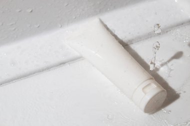 Cilt bakımı için maket tüpü şişesi. Su sıçraması, ürün markalaşması, serum damlası kremi tedavisi.