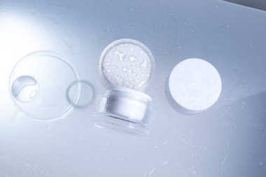 Makyaj kozmetik cilt bakımı krem losyon şişesi ürünleri için bir maket cam arka planda beyaz su damlasıyla ambalajlama.