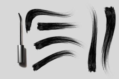 Makyaj malzemesi için leke boyalı maskara ve göz kalemi beyaz arka planda makyaj malzemesi modeli.