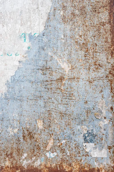 Grunge ripped poster background - texture of torn advertisement on an old rusty billboard panel.