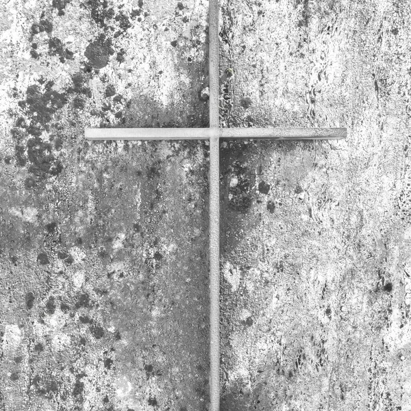 Iron christian cross on an old concrete wall. Easter. Religion.