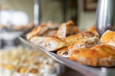 Focaccia ekmeği ve pizza dilimleriyle yakın plan. Ev yapımı Focaccia ve pizza aperatif olarak sunuldu. Parti. Olay. Odaklanmamış arkaplan.