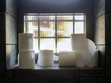 Eski bir tuvaletteki eski bir pencerenin tuvalet kağıdı rulolarını kapatın. Hijyen kavramı.