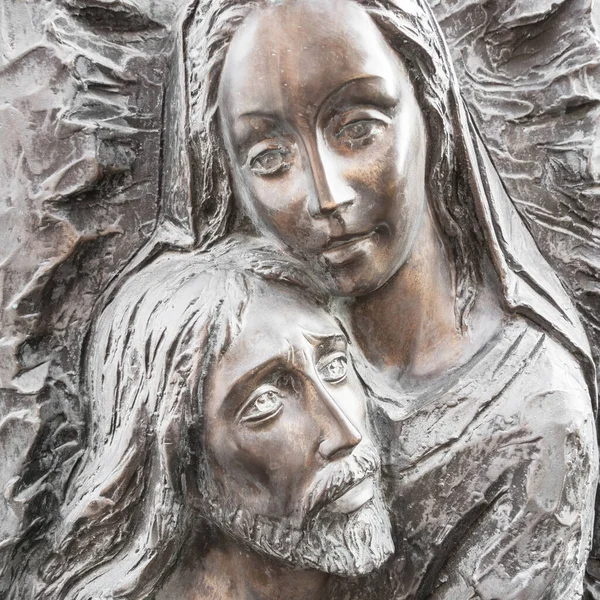 Jesus and Mary bronze statue. Bas-relief in bronze. Faces of Holy Mary mother and Jesus Christ after the Crucifixion. Easter.