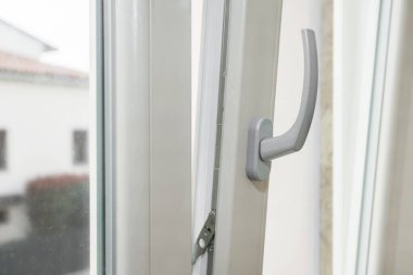 Bir apartmanın penceresi açık, içeri temiz hava giriyor. Enerji verimliliği.