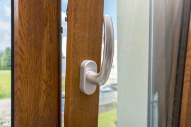 Ahşap pencere açık. Alt pencerede. Ahşap, metal, PVC kapı çerçeve yakın çekim görüntüsü. Kaliteli krom saplı. Enerji tasarrufu ve güvenlik profili. Yerleşim alanı arka planı bulanıklaştı.