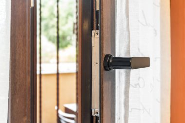 Bir apartmanın penceresi açık, içeri temiz hava giriyor. Enerji verimliliği.