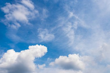 Açık mavi arkaplanda kabarık beyaz bulutlar