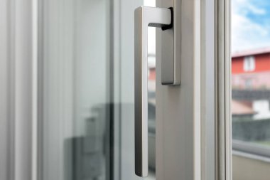 Alüminyum pencere açık. Metal kapı çerçeve yakın çekim görüntüsü. Ses yalıtımı. Enerji tasarrufu, güvenlik profili, bulanık bahçe arka planı.