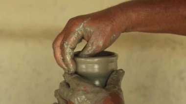 Çömlekçi elleri çömlek çarkı üzerinde çalışıyor ve tencere yapıyor..