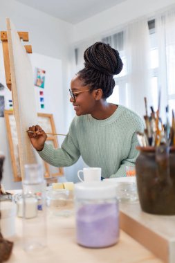Young painter working in her atelier