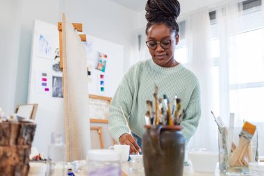 Young painter working in her atelier