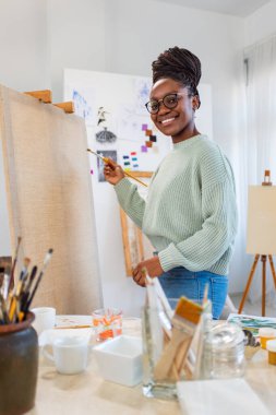Young painter working in her atelier