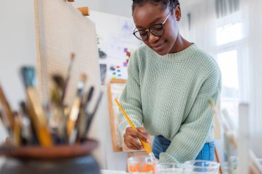 Young painter working in her atelier
