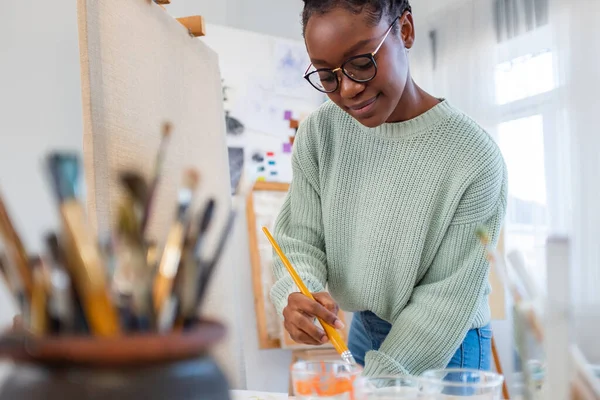 Young painter working in her atelier