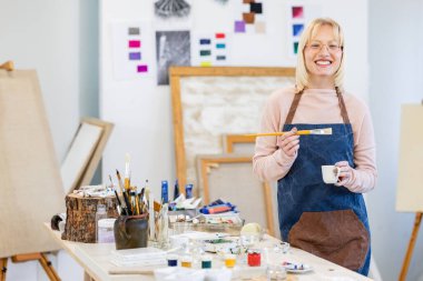 Young painter working in her atelier