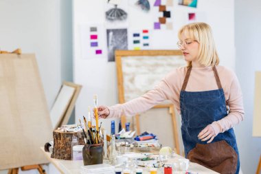 Young painter working in her atelier