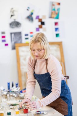 Young painter working in her atelier
